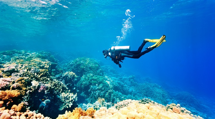 Female scuba diver swimming under water Blue Lagoon