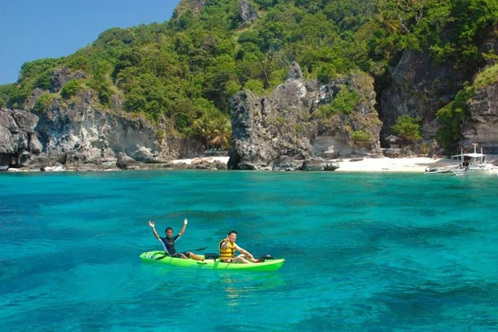 Guests kayaking below cliffs at Apo Island, Negros Oriental