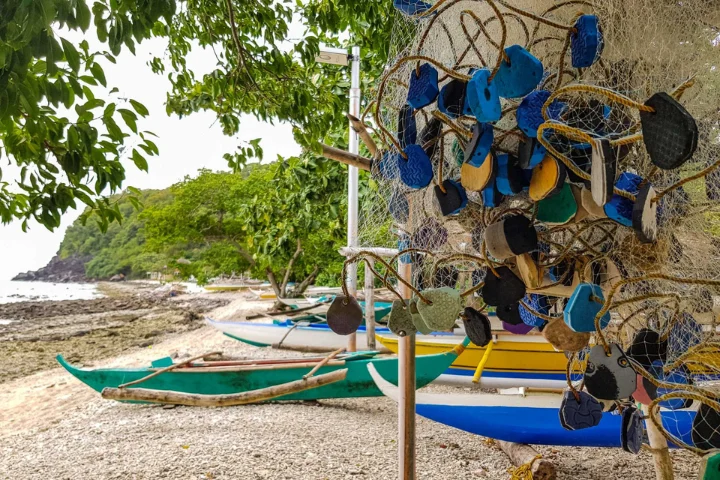 Outrigger boats and wind chimes on the beach of Apo Island